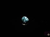 a close up of a blue diamond on a black surface