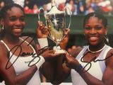 photo dédicacée de deux joueurs de tennis tenant un trophée devant un public