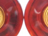 pair of red glass vases with gold medallions on them on a white surface