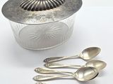five spoons and a bowl with a lid on a table