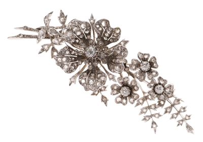 Une broche antique en forme de fleur sertie de diamants est présentée sur un fond blanc.