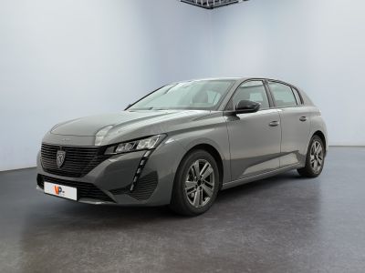 a grey car is parked in a room with a white wall