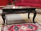 a coffee table with a glass top and a rug on the floor