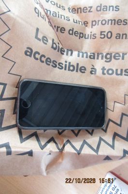 un téléphone portable posé sur un sac en papier brun
