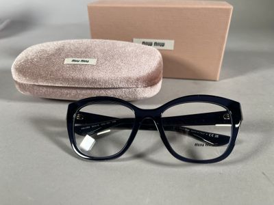 des lunettes sont posées sur une table à côté d'une boîte et d'une paire de lunettes