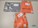 trois paires de t-shirts orange et bleus dans des sacs en plastique posés sur une table