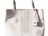 le sac à main blanc est posé sur une surface blanche et porte une étiquette