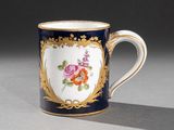 une tasse à café bleue et dorée décorée de fleurs