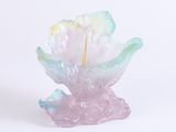 une petite fleur en verre d'où sort un bâtonnet doré
