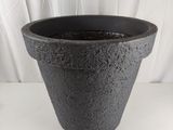 une photo d'un pot noir posé sur une table blanche