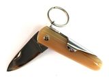 a small knife with a keychain on top of it