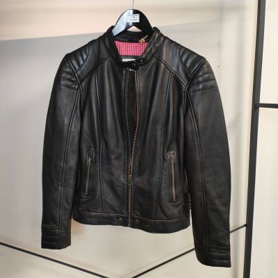 une veste en cuir noir suspendue à un porte-manteau dans une pièce