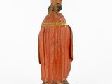 an old statue of a man wearing a red robe and a hat