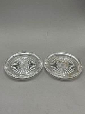a pair of glass ashtrays on a table