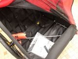 a red and black stroller with a bike inside of it
