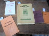plusieurs livres posés sur une table, recouverts de feuilles de papier