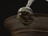 a brown vase with a handle on a black background