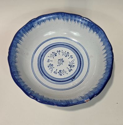 Grande coupe en faïence à décor de motifs floraux et filet b…