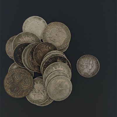 a pile of old coins on a black surface