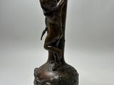 statue of a boy holding a vase on top of a wooden base