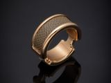 gros plan d'une bague en or sur une surface noire