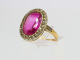 a close up of a pink stone ring on a white surface