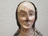 a wooden statue of a woman with a black head