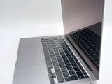 a silver laptop with a black keyboard on a white surface