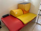 a yellow and red futon bed in a small room