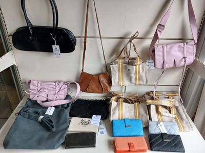 many purses and handbags on display on a table