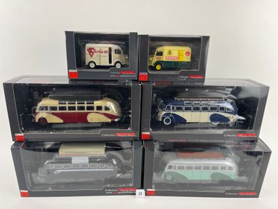 six petits bus jouets emballés dans leurs boîtes, posés sur une surface blanche