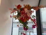 a vase of flowers hanging from a window in a building