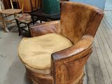 a brown leather chair with fringes on it in a room