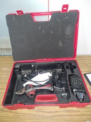 une mallette rouge contenant des outils, posée sur une table en bois