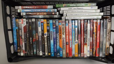 un panier noir rempli de DVD posé sur une table