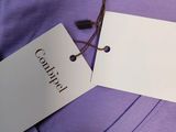 a purple shirt with a tag on it and a tag attached to it