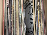 une boîte en carton remplie de disques de toutes sortes