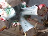 a cross made out of clay with flowers on top of it