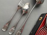 four spoons and two forks sitting on a table