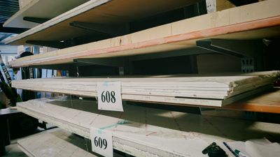 beaucoup d'étagères vides dans un magasin, avec des étiquettes de prix dessus