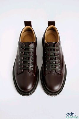 a close up of a pair of brown shoes on a white surface