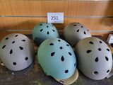quatre casques sont alignés sur une table, accompagnés d'une étiquette de prix