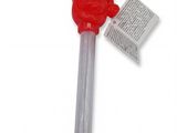 une cuillère en plastique avec un manche rouge et un bout de papier posé dessus