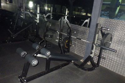 une salle de sport équipée d'un banc, d'haltères et d'autres appareils