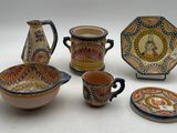 cinq pièces de poterie posées sur une surface blanche