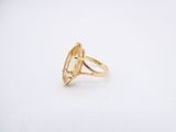 a yellow gold ring with an oval stone in the center