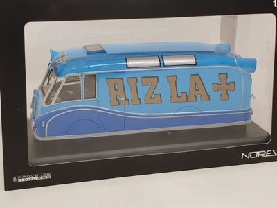 a blue toy bus in a black box on a white surface