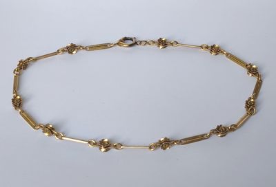 un bracelet en chaîne d'or orné d'un motif floral