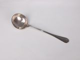 a silver spoon with a spoon handle on a white surface