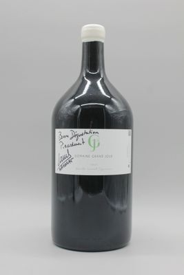 une bouteille contenant un liquide noir posée sur une table blanche